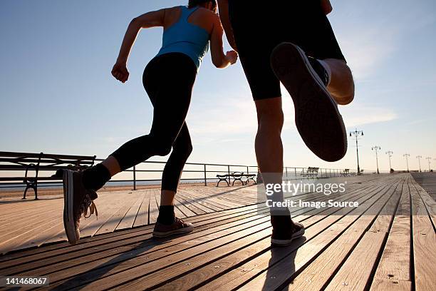 two people running on promenade - 50 sombras fotografías e imágenes de stock