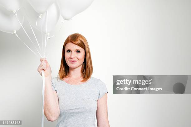 young woman holding balloons - person holding a balloon stock pictures, royalty-free photos & images