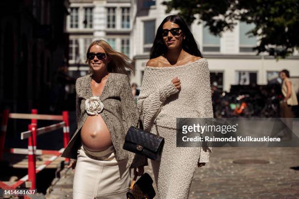 Pregnant Hanna Stefansson wearing white long skirt, long black shoes, light brown jacket with a white flower and brown bag and Babba C Rivera wearing...