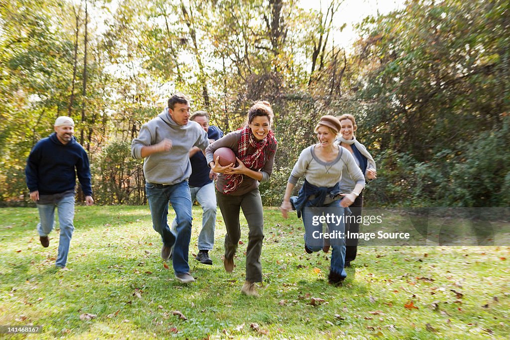 Mature friends playing football