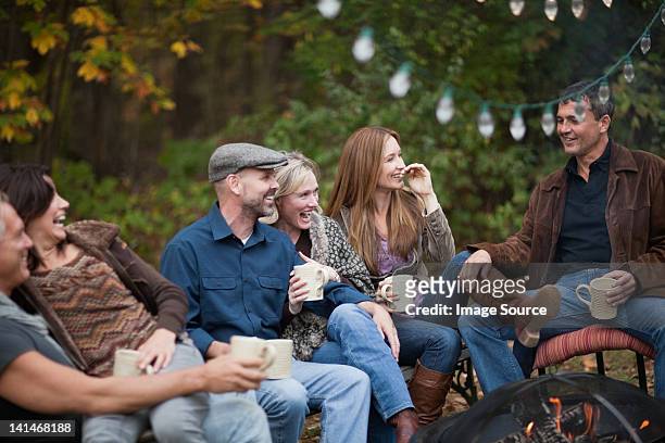 smiling friends outdoors by fire - amplified heat stock pictures, royalty-free photos & images