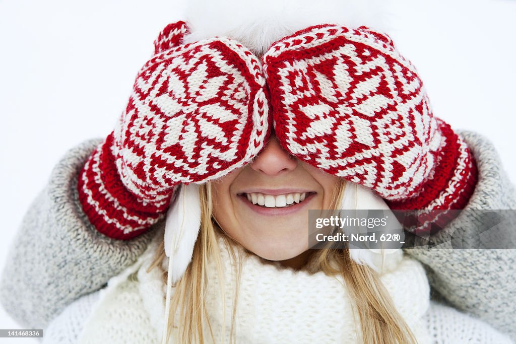 Girl having eyes covered by person wearing gloves