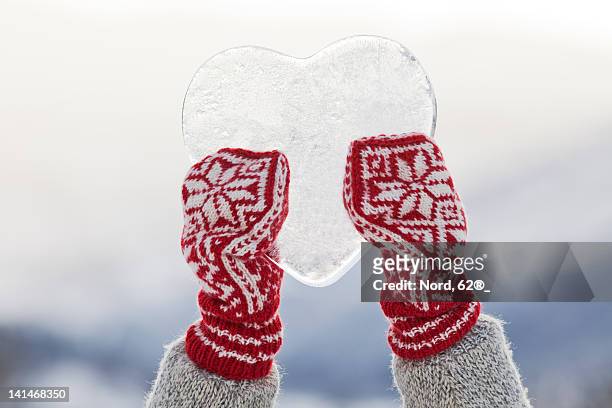 person holding heart shaped ice - mitten foto e immagini stock