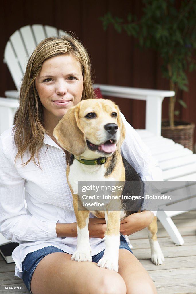 Portrait of young woman with dog on porch