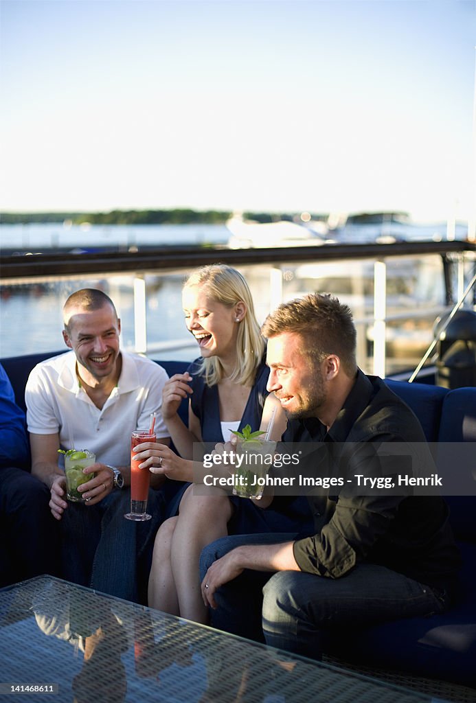 People drinking and laughing in outdoor restaurant