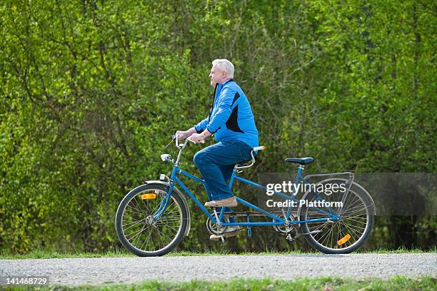 senior man on tandem bike - tandem stock pictures, royalty-free photos & images