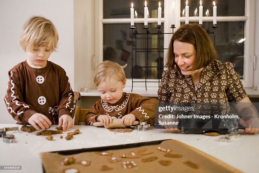 Mother with son and daughter preparing gingerbread biscuit