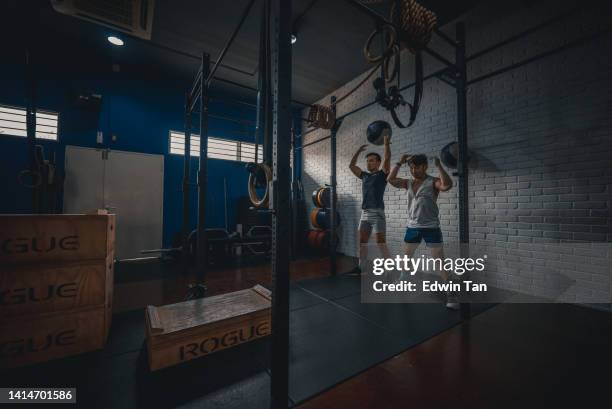 couple gay chinois asiatique pratiquant des balles murales ensemble dans la salle de sport - gay bodybuilder photos et images de collection