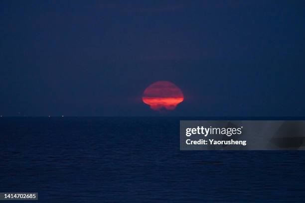 full orange moonrise over sea - mushroom cloud stock pictures, royalty-free photos & images