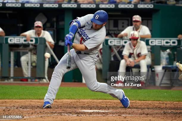 Max Muncy of the Los Angeles Dodgers hits an RBI double in the sixth inning against the Kansas City Royals at Kauffman Stadium on August 13, 2022 in...