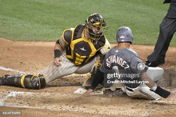 Cesar Hernandez of the Washington Nationals slides past Austin Nola of the San Diego Padres to score on Victor Robles hit in the seventh inning...