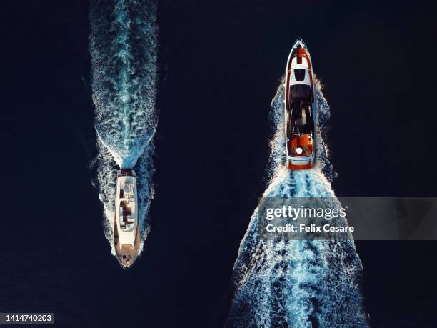 aerial view of two motor yachts cruising in opposite direction. - forte contrasto foto e immagini stock