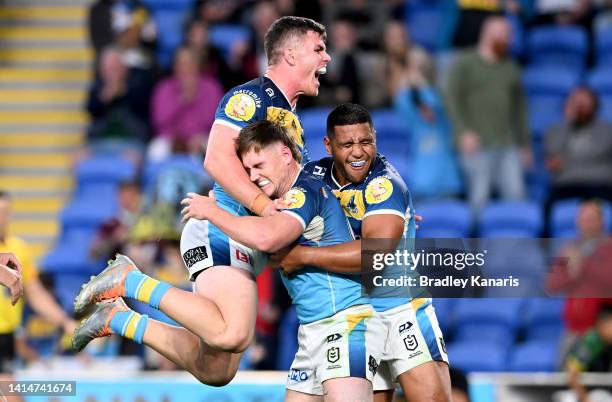 Alexander Brimson of the Titans is congratulated by team mates after scoring a try during the round 22 NRL match between the Gold Coast Titans and...