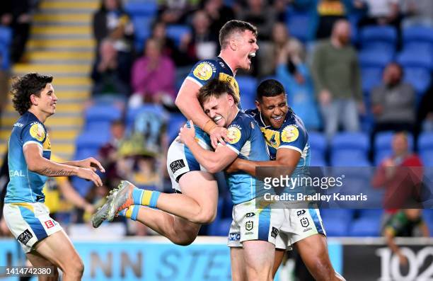 Alexander Brimson of the Titans is congratulated by team mates after scoring a try during the round 22 NRL match between the Gold Coast Titans and...