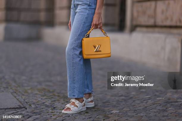 Mandy Bork seen wearing Louis Vuitton yellow Twist leather bag, Agolde blue straight leg jeans and white Chanel sandals, on August 12, 2022 in...