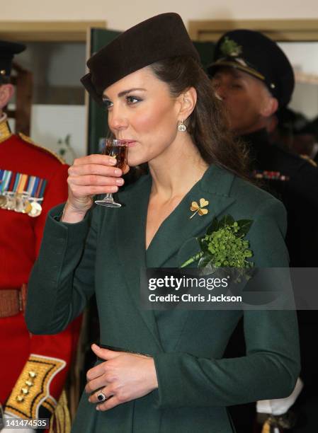 Catherine, Duchess of Cambridge holds a glass of Harvey's Bristol Creme in the Junior's Mess as she visits Aldershot Barracks on St Patrick's Day on...