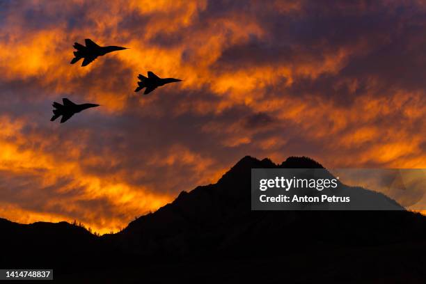 jet fighters at sunset in the sky - luchtaanval stockfoto's en -beelden