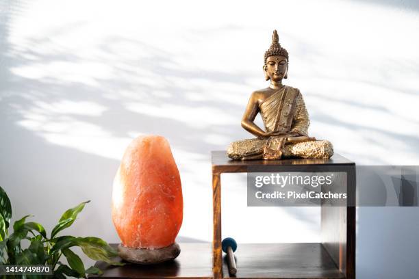 goldener buddha und himalaya-salzlampe - himalayan salt stock-fotos und bilder