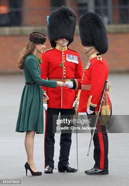 Catherine, Duchess of Cambridge presents 'shamrocks' as she takes part in a St Patrick's Day parade as she visits Aldershot Barracks on St Patrick's...