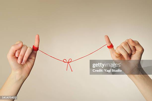 the hand of the man and woman connected with a red - hands tied up stock pictures, royalty-free photos & images