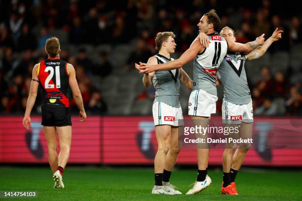 Jeremy Finlayson of the Power celebrates kicking a goal as Dyson Heppell of the Bombers reacts during the round 22 AFL match between the Essendon...