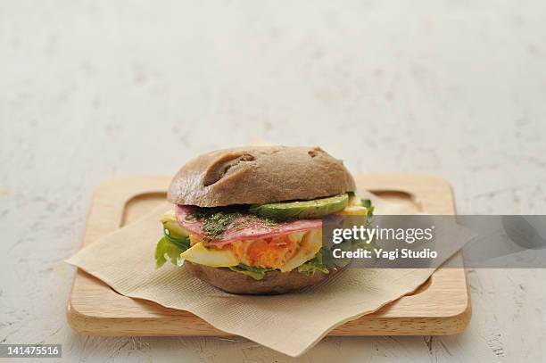 egg, avocado and ham bagel sandwiches - immagine on white board foto e immagini stock