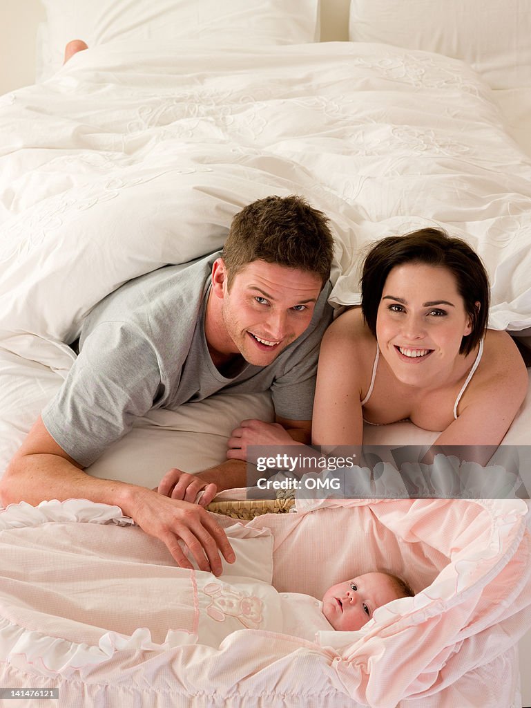 Couple with baby in bed