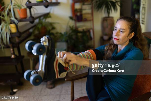 woman tying shoelaces of vintage roller skates - offbeat stock-fotos und bilder