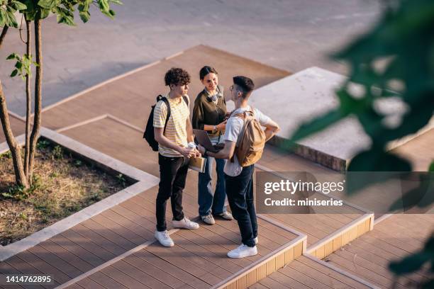 three students having fun while talking and standing outdoors - working on laptop in train top view stock pictures, royalty-free photos & images