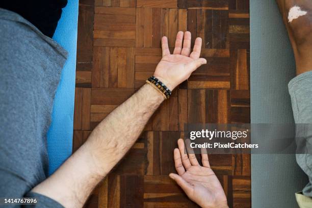 close up of mens hands lying in shavasana - savasana stock pictures, royalty-free photos & images