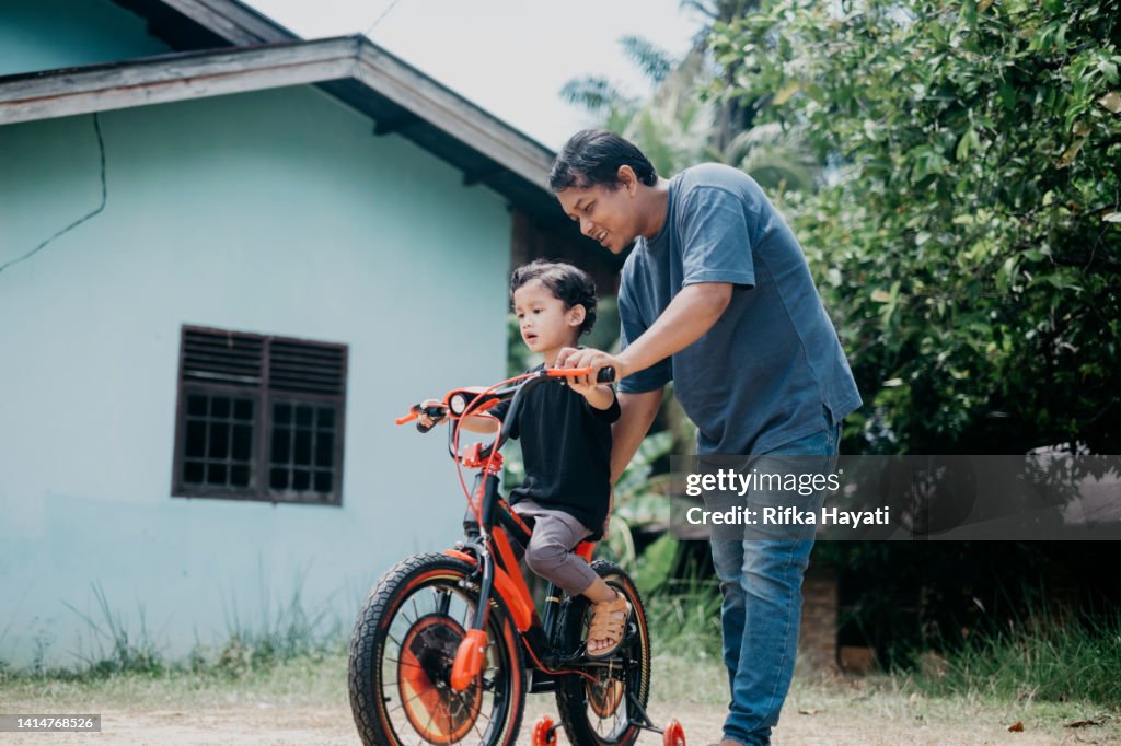 Father and son on a bicycle lane stock photo