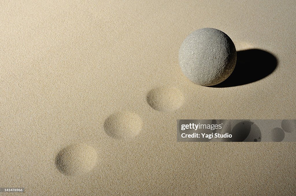 The ball in the sand pit and stone ruins of a sphe