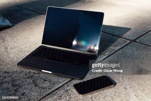 a laptop and a smart phone with blank screen on the ground - laptop and iphone mockup stock pictures, royalty-free photos & images