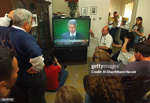 Gonzalez family spokesperson Armando Gutierrez, left, and supporters watch President Bill Clinton speak in the living room of the Gonzalez''s Miami...