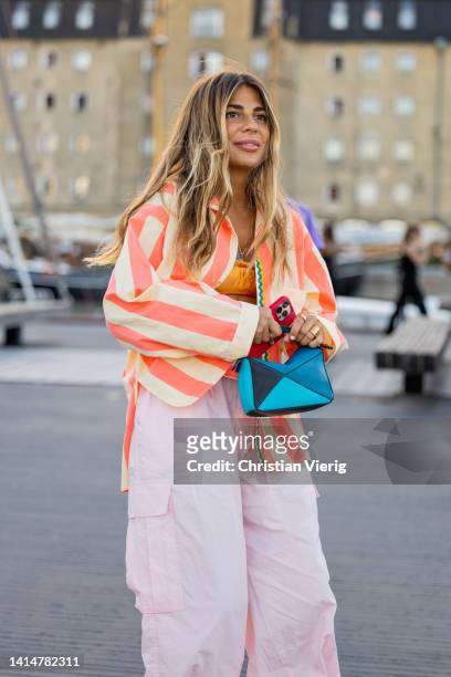 Guest is seen wearing red white striped blazer, pink pants, blue Loewe bag outside Ganni during Copenhagen Fashion Week Spring/Summer 2023 on August...