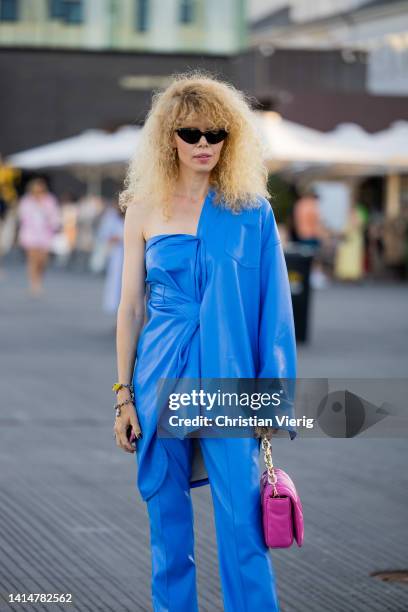 Guest is seen wearing blue blazer, top, pants, pink bag outside Ganni during Copenhagen Fashion Week Spring/Summer 2023 on August 11, 2022 in...
