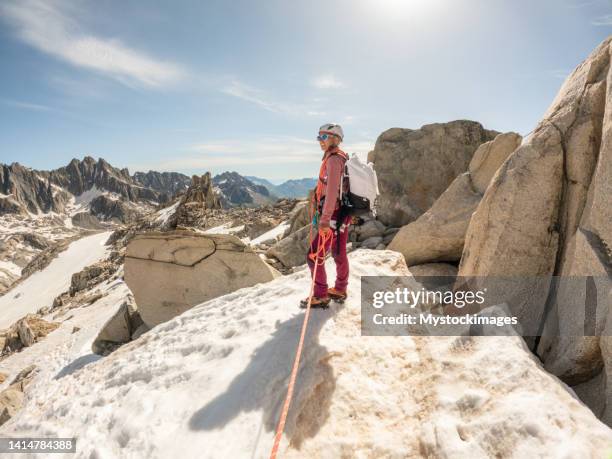 klettererin führt den weg zum letzten schritt auf einem felsgipfel - climbing rope stock-fotos und bilder