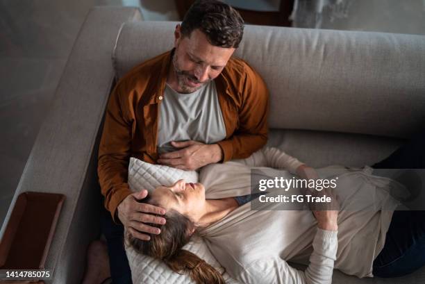 mature couple talking on the couch at home - tired couple stock pictures, royalty-free photos & images
