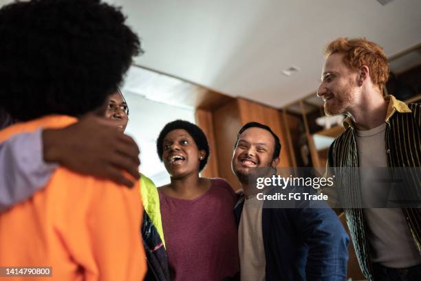 amigos hablando y abrazándose en casa - neurodiversidad fotografías e imágenes de stock