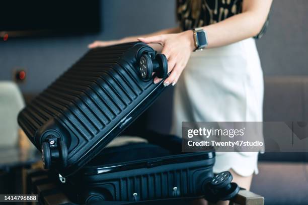 a woman packing a suitcase for travel - valise stock-fotos und bilder