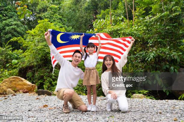 famiglia asiatica che celebra il merdeka day nel parco pubblico - malaysia independence day foto e immagini stock