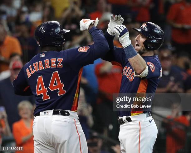 Alex Bregman of the Houston Astros receives a high five from Yordan Alvarez after hitting a two run home run in the first inning against the Oakland...