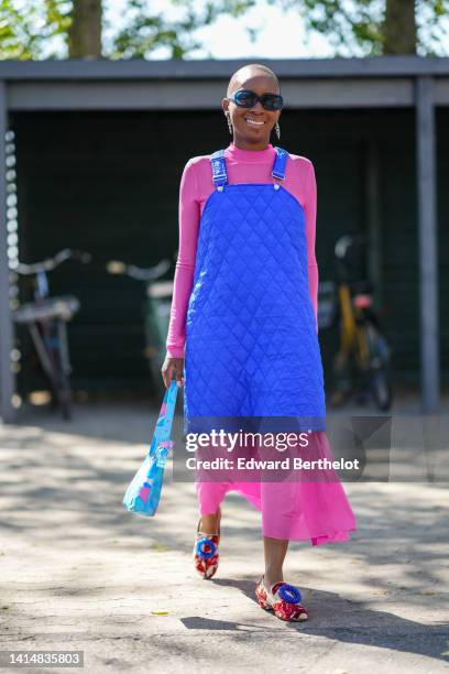 Guest wears navy blue sunglasses, a pink long sleeves pleated dress, a royal blue quilted tank-top dress, a pink and blue print pattern nylon...