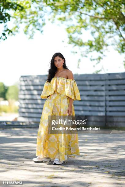 Guest wears gold earrings, a yellow with green / pink flower print pattern shoulder-off / ruffled long dress, a pale yellow matte leather Baguette...
