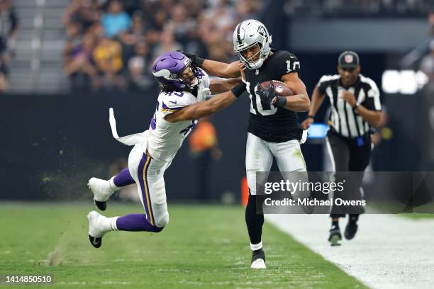 Mack Hollins of the Las Vegas Raiders stiff arms Troy Dye of the Minnesota Vikings during the first half of a preseason game at Allegiant Stadium on...