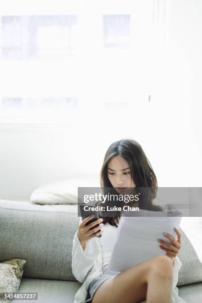 young asian woman using smartphone to pay financial bill at home - avoid stock pictures, royalty-free photos & images