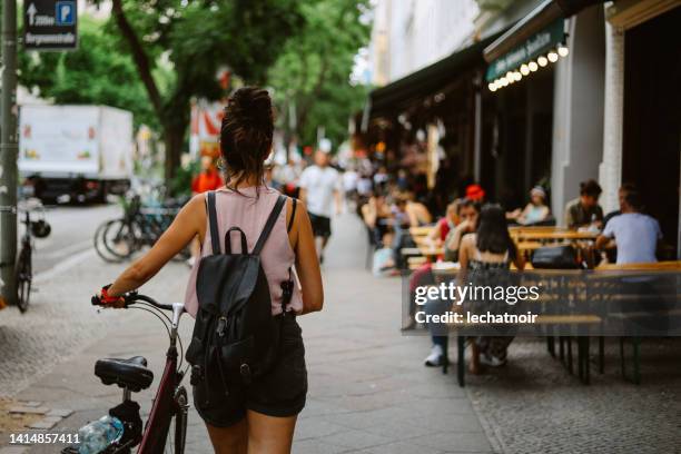 mulher empurrando sua bicicleta nas ruas de berlim - kreuzberg - fotografias e filmes do acervo