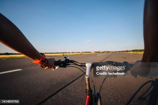 woman riding her bicycle in tempelhof, berlin - tempelhof airport stock pictures, royalty-free photos & images