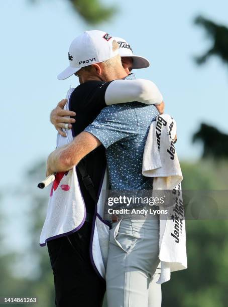 Will Zalatoris of the United States reacts with his caddie Joel Stock after putting in to win on the third playoff hole on the 11th green during the...