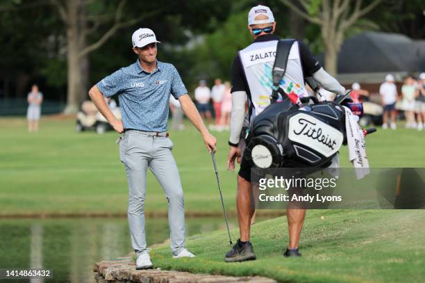 Will Zalatoris of the United States talks with his caddie on the third playoff hole on the 11th green after his ball went in the water during the...